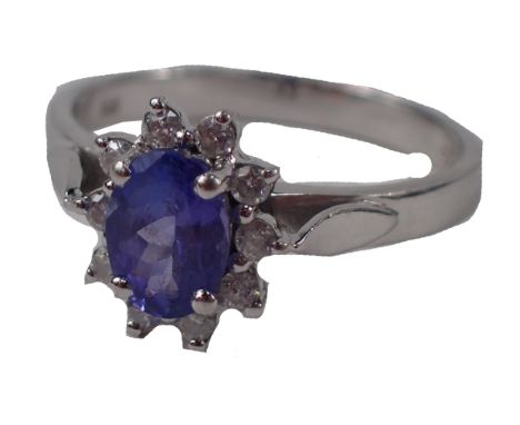 A cluster ring, with oval cut purple stone, surrounded by tiny diamonds in white gold setting, stamped 14kt, size N 1/2, 3.3g