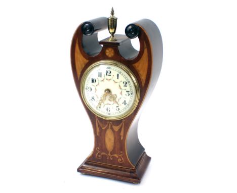 An Edwardian mantel clock, of scroll form, with brass bulbous central finial, on a cream enamel numeric dial with painted bow