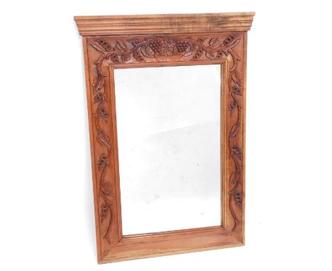 An Eastern carved hardwood mirror, the top with a moulded edge above a rectangular mirrored panel surrounded by carved grapes