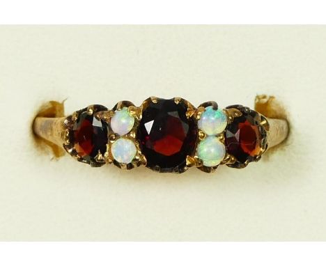 An Edwardian three stone garnet ring with opal points between, V, 3.4gm. 