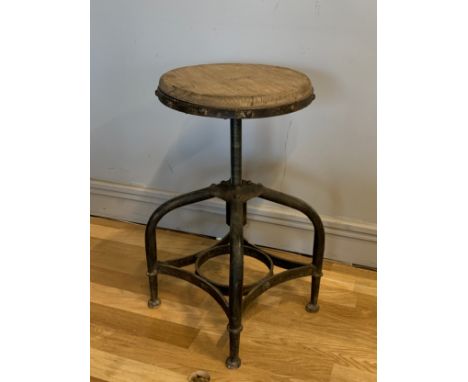 An industrial rotary workshop stool, having adjustable swivel pine disc seat on four curved steel legs with stretcher. 