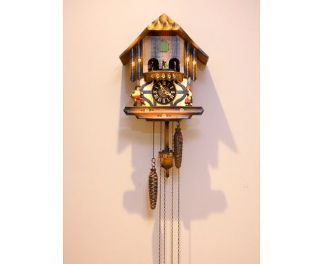 A mid 20th century Black Forest cuckoo clock, having musical carousel, with mechanical three weight movement.30cm long (clock