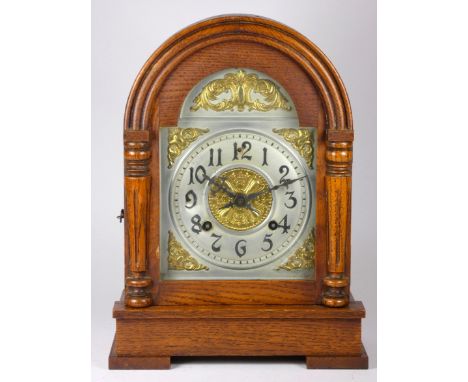An early 20th century Asonia oak cased mantel clock, silvered chapter ring, dial with gilt embossed decoration, 8 day movemen