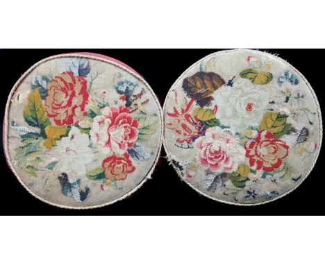 A pair of Victorian circular wooden frame footstools, on squat bun feet, upholstered in tapestry and beadwork with summer flo
