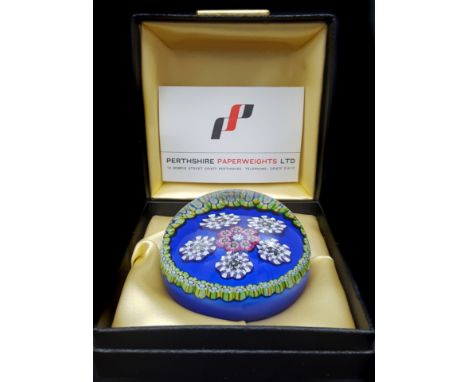 A Perthshire glass 1975 cushion ground paperweight, of six clusters of millefiori canes set on a bright blue cushion backgrou