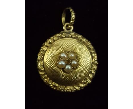 An early 19thC split pearl and gold locket set to the centre with five small split pearls within an engine turned and carved 
