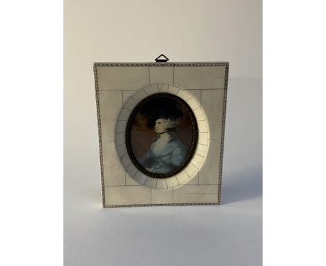 A 20th century Continental portrait miniature depicting a fashionable lady, displayed in a bone frame, indistinctly signed, 1