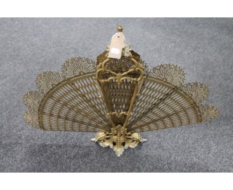 A decorative brass peacock fire screen 