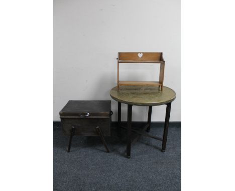 An Edwardian oak two tier wall shelf together with a folding eastern brass topped table and a mid century sewing box 