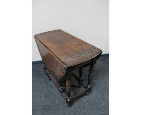 An antique carved oak gate leg table 