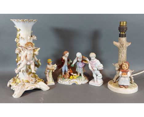 A German porcelain lamp base decorated with putti, together with a Goebels lamp and three Continental porcelain figures 