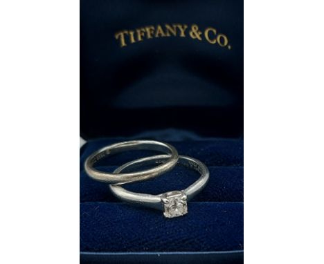 A Tiffany and Co. Lucida Platinum solitaire Diamond ring, 0.32ct, ring size J, 3.6gms together with a Platinum wedding band b