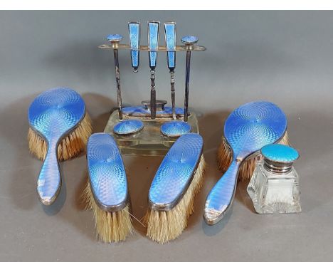 A Birmingham silver and blue enamel dressing table set comprising a manicure set, four brushes and a similar scent bottle 