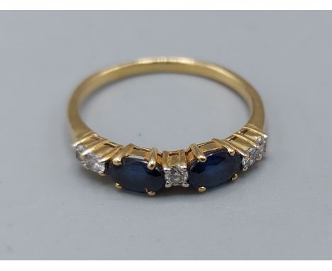 An 18ct gold Sapphire and Diamond band ring set with two Sapphire and five Diamonds, 2.8gms, ring size T 