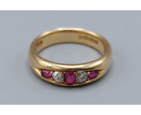An 18ct gold Ruby and Diamond ring set with three Rubies and two Diamonds, 6.3gms, ring size M 