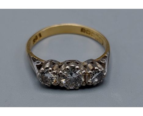 An 18ct gold three stone Diamond ring, the three graduated Diamonds claw set, 3.2gms, ring size O 