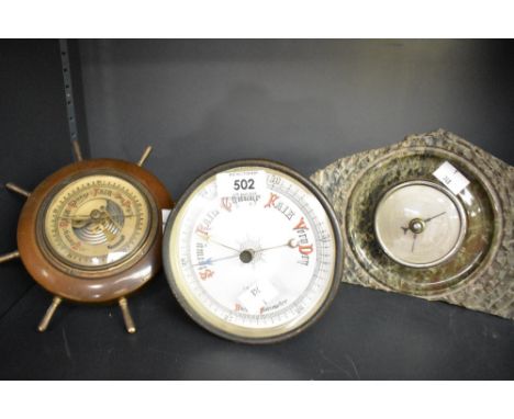 A partially turned and polished serpentine mantel barometer 15cm sold along with a decorative Lorister ships wheel form barom