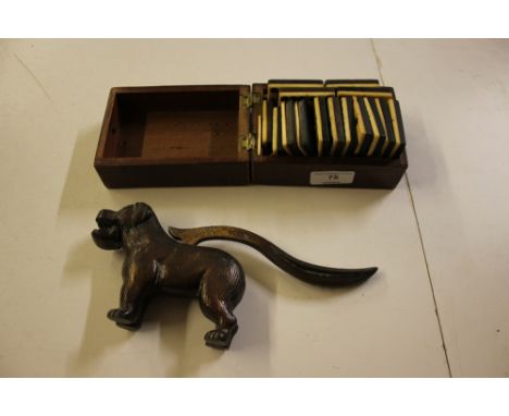 A wooden cribbage board containing a set of dominoes; and a novelty nut cracker in the form of a dog 