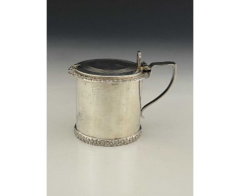 An Elizabeth II silver mustard pot, of drum form, modelled in the Regency style, with cast foliate borders, ensuite with blue