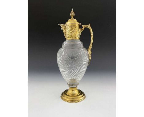 A Victorian silver-gilt mounted claret jug, the cut glass body decorated with flowerheads and scrolls, the silver-gilt mount 