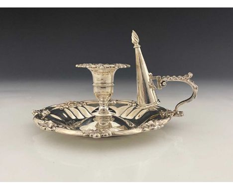 An early Victorian silver chamberstick, with fluted circular base bordered by flowerheads, foliage and scrolls, the C-scroll 