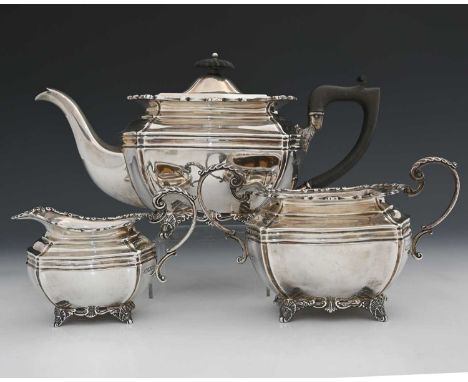 An Edwardian silver three-piece tea service, comprising teapot, two-handled sugar bowl, and cream jug, each of panelled ovoid