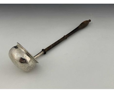 An early nineteenth-century toddy ladle, the silver-coloured metal globular body with flared rim, the underside decorated wit