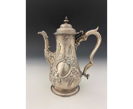 A George II silver coffee pot, of baluster form, the body with Rococo-revival scroll and flowerhead decoration, the cast spou