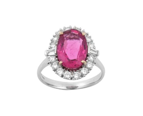 An 18 Carat Gold Pink Tourmaline and Diamond Cluster Ringthe oval cut pink tourmaline within a border of round brilliant cut 
