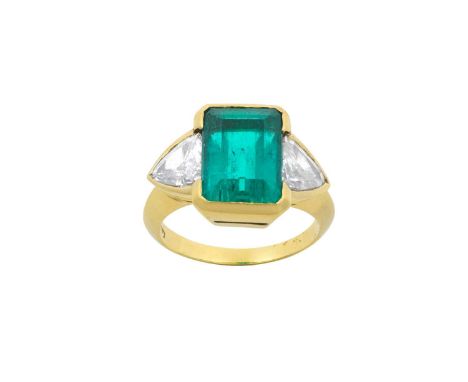 An Emerald and Diamond Three Stone Ringthe emerald-cut emerald flanked by trilliant cut diamonds, in yellow rubbed over setti