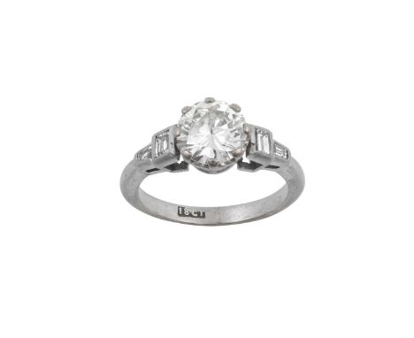 A Diamond Solitaire Ringthe round brilliant cut diamond in a white claw setting, to stepped baguette cut diamond shoulders in