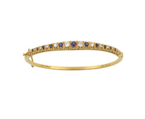 An 18 Carat Gold Sapphire and Diamond Bangleeleven graduated round cut sapphires alternate with twelve round brilliant cut di