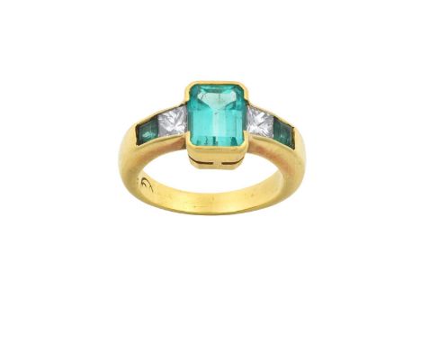 An Emerald and Diamond Ringthe emerald-cut emerald flanked by a princess cut diamond and a square cut emerald to each side, i