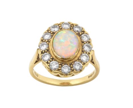 An 18 Carat Gold Opal and Diamond Cluster Ringthe oval opal cabochon in a yellow rubbed over setting, within a border of roun