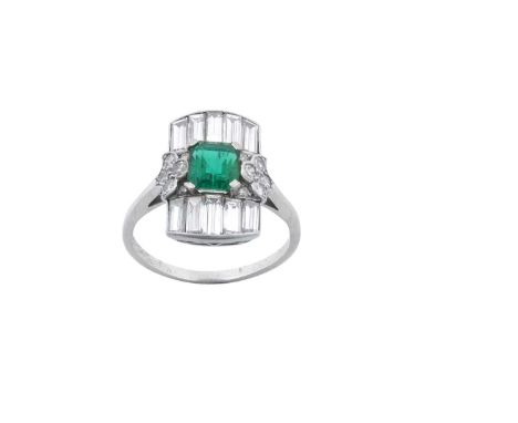 An Art Deco Emerald and Diamond Cluster Ringthe emerald-cut emerald to a rectangular plaque of baguette cut diamonds, with ei