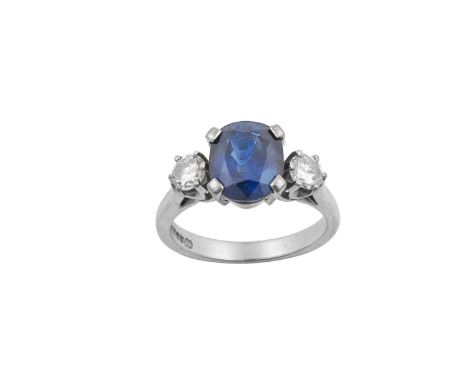 An 18 Carat White Gold Sapphire and Diamond Three Stone Ringthe oval cut sapphire flanked by round brilliant cut diamonds, in