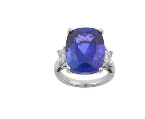 A Tanzanite and Diamond Ringthe cushion cut tanzanite flanked by emerald-cut diamonds, in white claw settings, to a tapered s