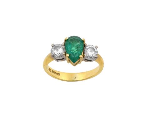 An 18 Carat Gold Emerald and Diamond Three Stone Ringthe pear cut emerald in a yellow claw setting, flanked by round brillian