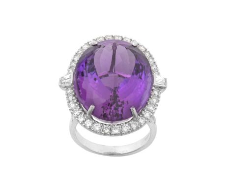 An 18 Carat White Gold Amethyst and Diamond Cluster Ringthe oval cut amethyst with a pair of tapered baguette cut diamonds on