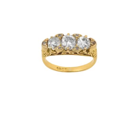 A Diamond Three Stone Ringthe graduated old cut diamonds spaced by rose cut diamond accents, in yellow claw settings, with a 