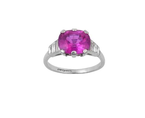 A Pink Sapphire and Diamond Ringthe deep pink cushion mixed cut sapphire within white broad claws, with trios of graduated ba