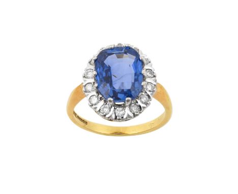 An 18 Carat Gold Sapphire and Diamond Cluster Ringthe cushion cut sapphire within a border of round brilliant cut diamonds, i