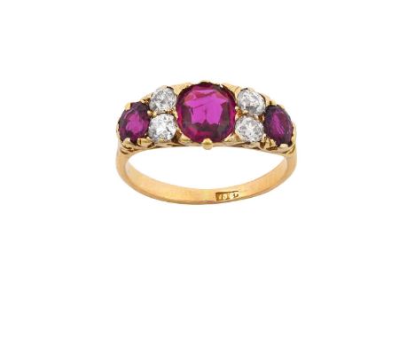 A Ruby and Diamond Ringthree cushion cut rubies spaced by pairs of old cut diamonds, in yellow claw settings, with a scroll g