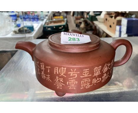 A Chinese Yixing terracotta coloured stoneware teapot of squat circular form, square impressed seal mark to base and handle, 