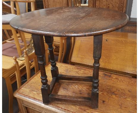 A reproduction oak occasional table with oval drop leaf top; an armchair with rush seat and ladder back 