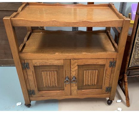 A light oak 'Agincourt' tea trolley with double shelves over double linenfold panel doors 