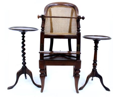 A 19TH CENTURY CHILD'S HIGH CHAIR with caned back and seat and adjustable foot rest, and on a stand with turned shaped front 