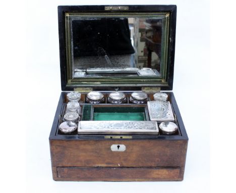 A 19TH CENTURY BURR WALNUT VANITY CASE the mirror lined lifting top, opening to reveal cut glass bottles and boxes with silve