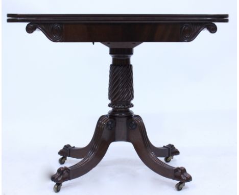 A 19TH CENTURY MAHOGANY REGENCY STYLE FOLD OVER CARD TABLE with green baize lining standing on a quadripartite base terminati