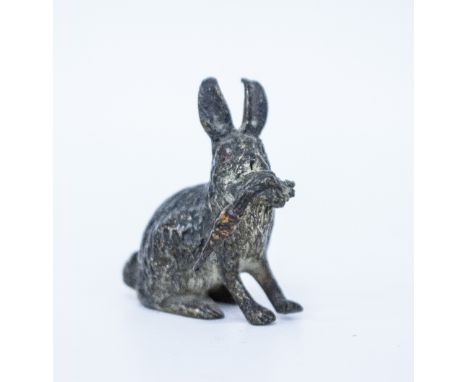 AN AUSTRIAN COLD PAINTED MODEL OF A RABBIT with a carrot, marked Gescutz to the base, 3.5cm high